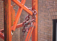Failing to weld the safety chain to the eyebolt of a material hoist helped lead to a fatal accident.
