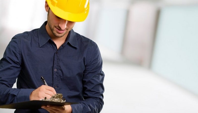 Man with hardhat using clipboard that could be a checklist